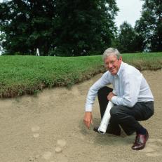 Landscape architect Arthur Hills squats in a sand trap holding blueprints in one hand on the Inverness Club golf course, a course he re-designed. (Photo by �� Tony Roberts/CORBIS/Corbis via Getty Images)