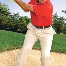 The key to breaking 90 is being able to save strokes from more difficult places, like a downhill lie in a bunker. Use your most lofted wedge, and open the face before taking your grip. Set up with your weight on your front side, then keep your lower body still with very little turn throughout the shot. This helps you maintain your balance.



 Your arms should dominate the swing. An early wrist hinge sets up a vertical backswing, allowing you to strike down and through the sand. It takes courage to make a firm, accelerating blow about four inches behind the ball. Make sure the clubhead doesn\'t pass your hands until the ball is well on its way, and allow for extra roll. You need to practice this shot to pull it off under pressure.