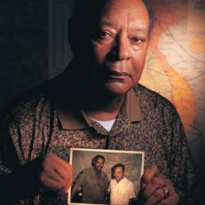 Earl Woods in 1997, holding a photo of his friend Tiger Phong.