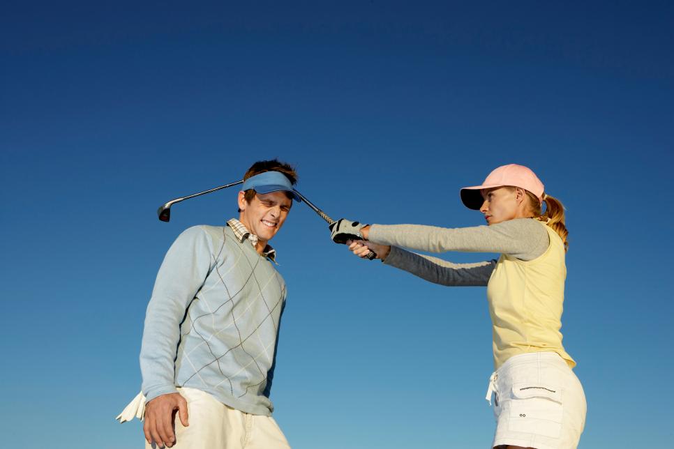 Woman Hitting a Man Over the Head With a Golf Club