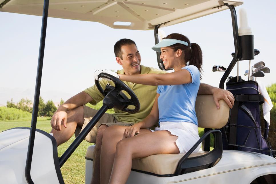 Couple smiling at each other in golf cart