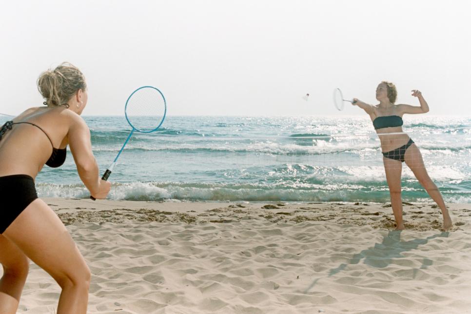 Woman playing badminton at beach
