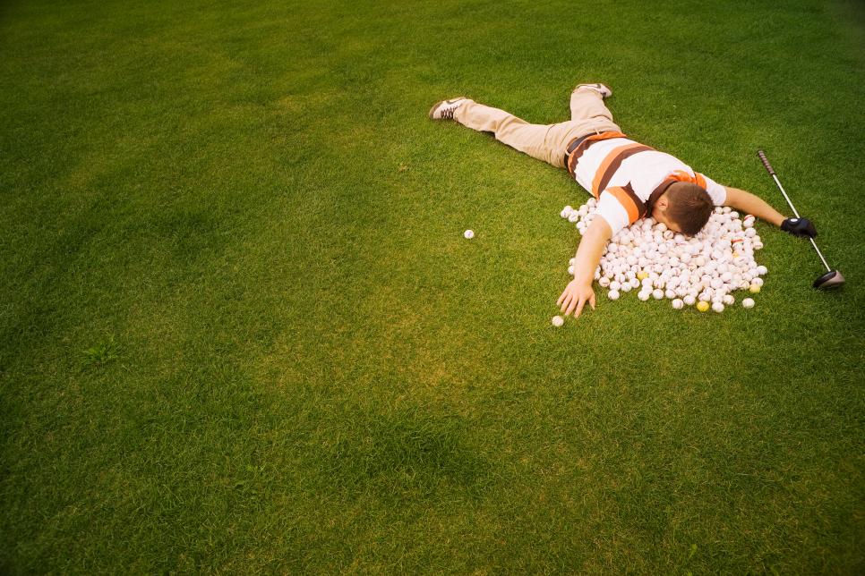 High angle view of a man lying on golf balls