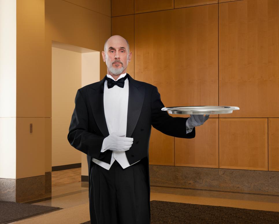 Serious butler holding tray