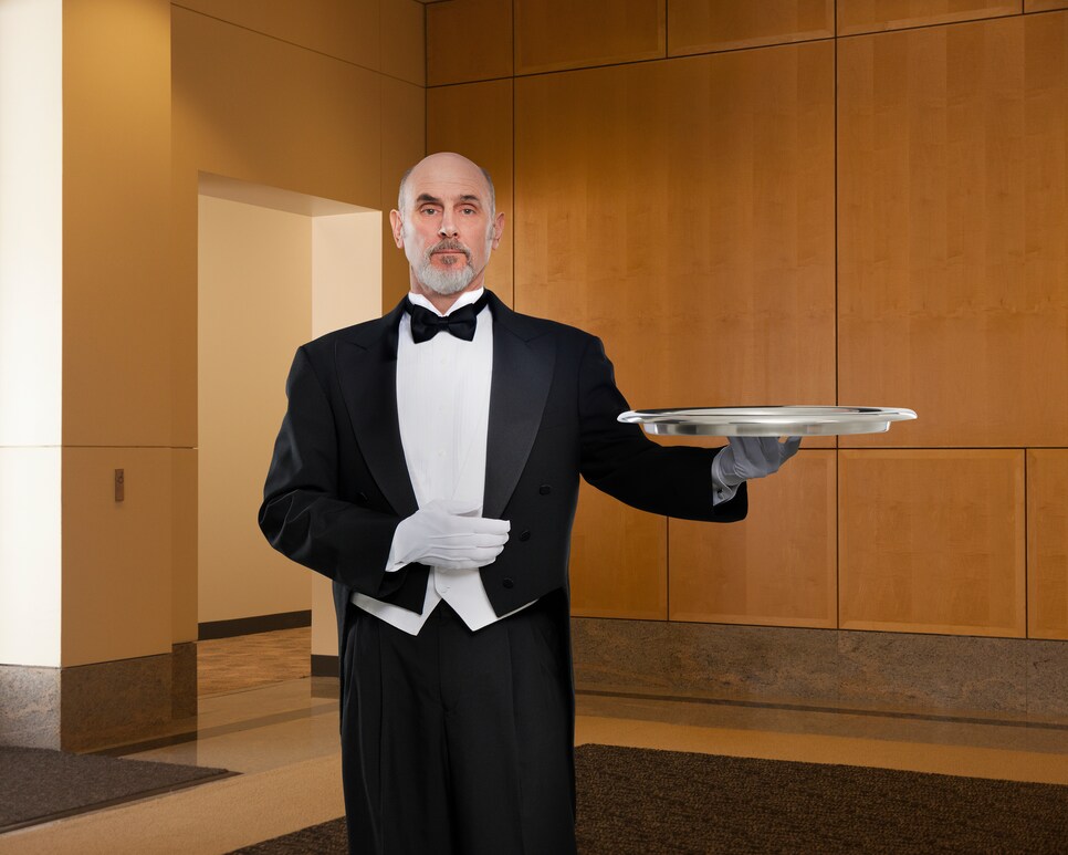 Serious butler holding tray