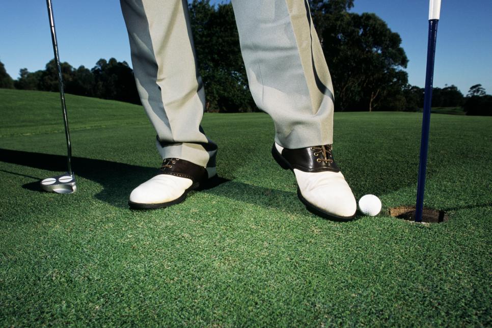 Golfer Pushing Ball Into Hole With His Foot