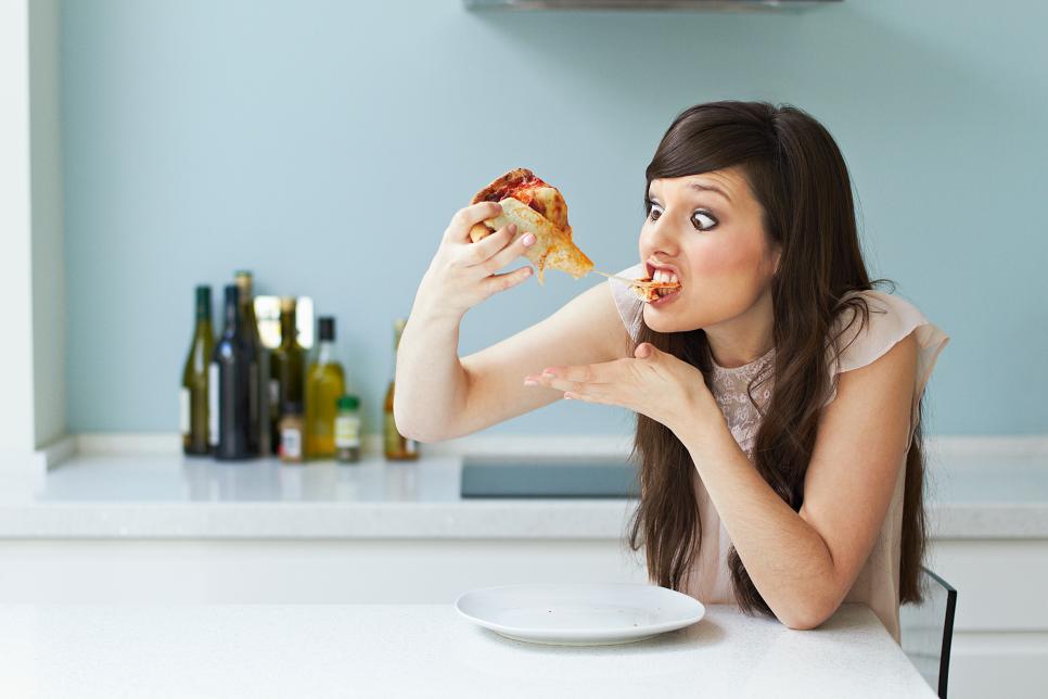 Portrait of woman eating pizza