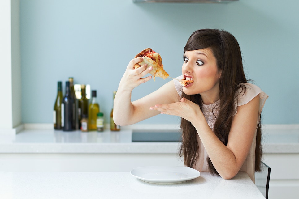 Portrait of woman eating pizza