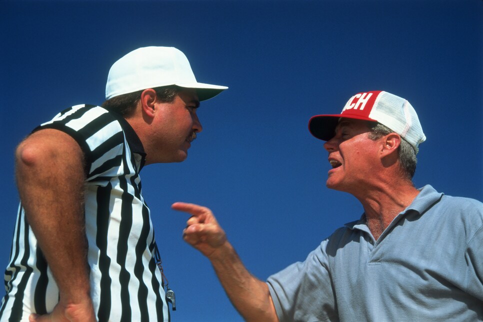 Referee and coach arguing, close-up