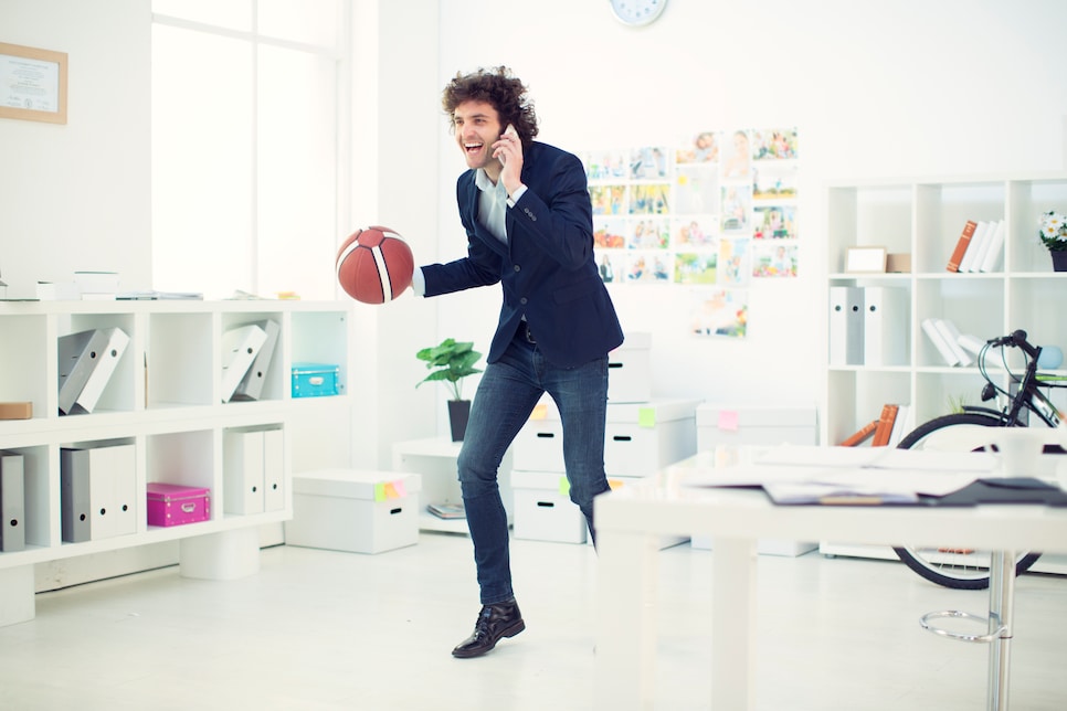 Businessman with basketball in office.