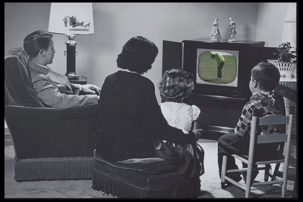 FAMILY WATCHING TV IN A LIVING ROOM SETTING