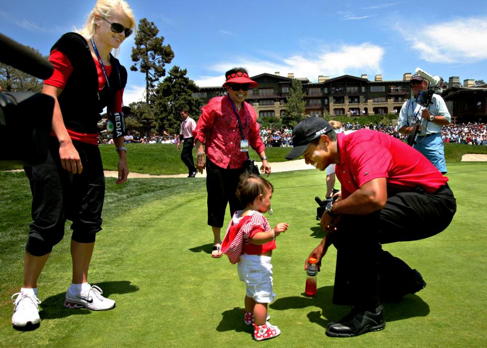 Golfer Tiger Woods, right, greets his daughter Sam, center,