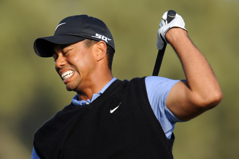 Tiger Woods winces in pain as he follows