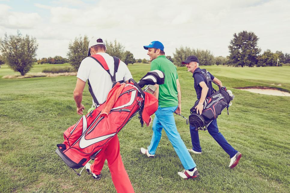 Mid-adult men talking on golf course