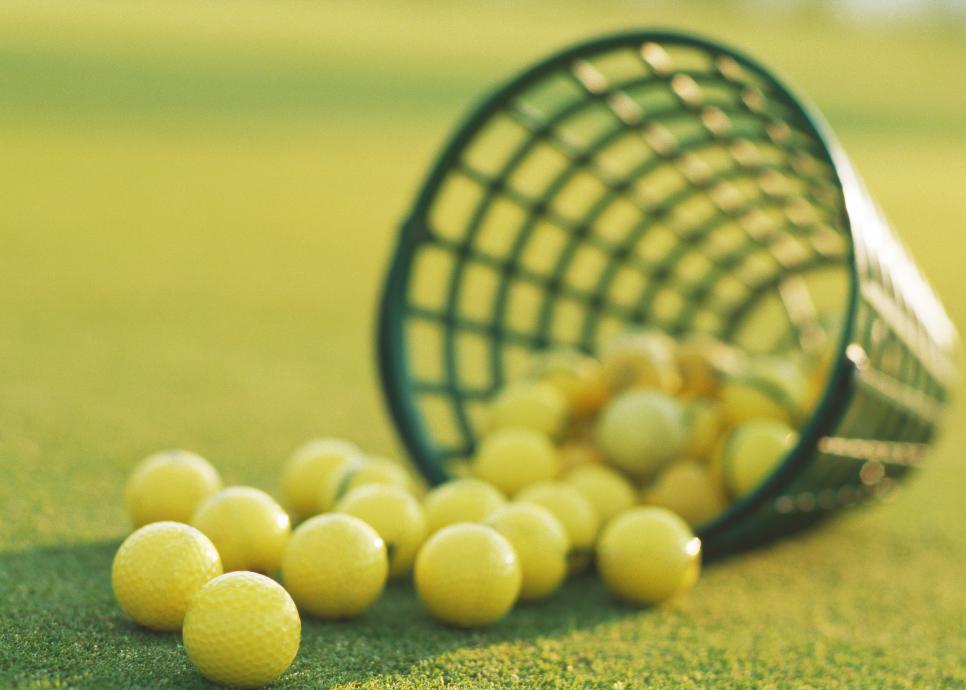 Spilled basket of yellow golf balls, close-up