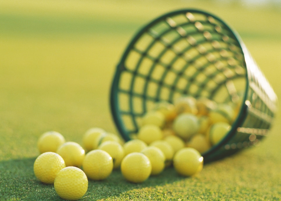 Spilled basket of yellow golf balls, close-up