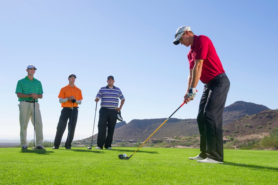 Men playing golf on course