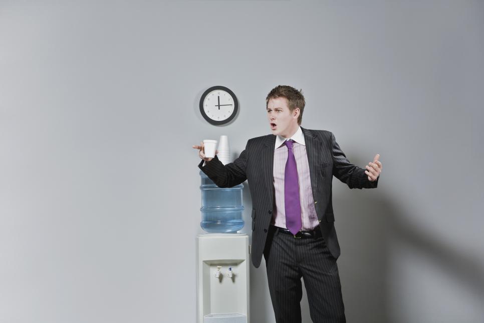 Businessman looking surprised near a water cooler