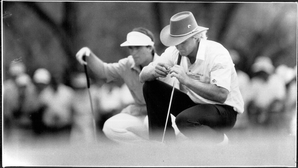 Craig Parry, background, lines up his putts as a disappointed Greg Norman ponder his next move during yesterday's round at Riverside Oaks, where he returned a four-under par 68.