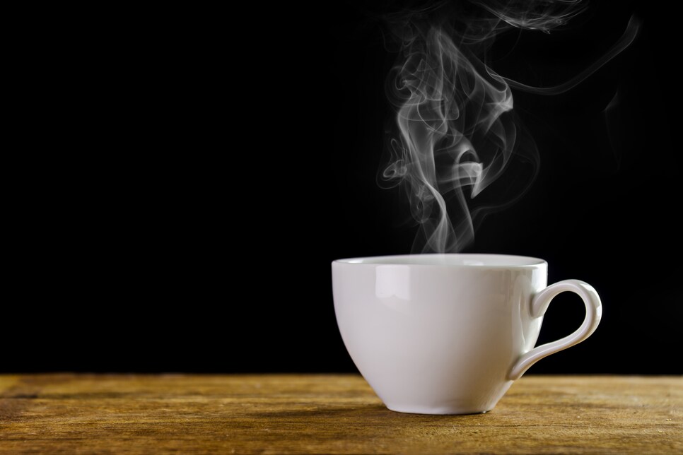 Close-Up Of Coffee Cup On Table Against Black Background