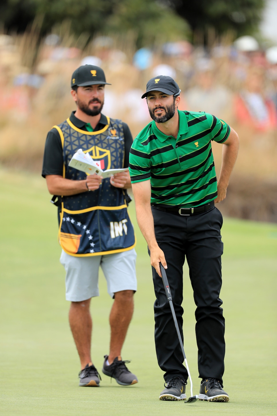 adam-hadwin-caddie-presidents-cup-2019-18th-green-singles-lining-up-putt.jpg