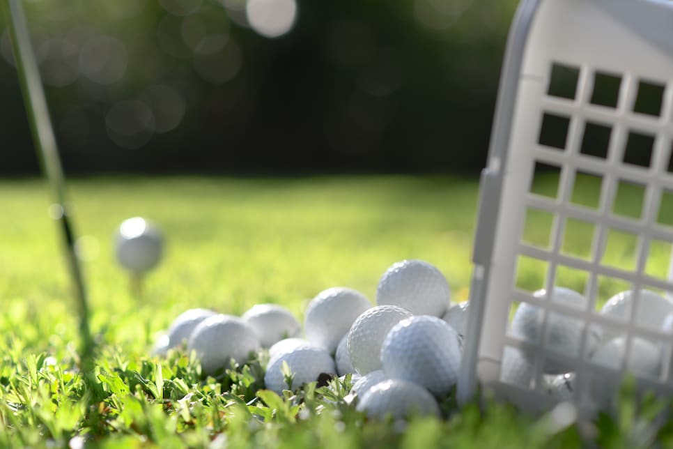 Golf balls in basket on green grass for practice