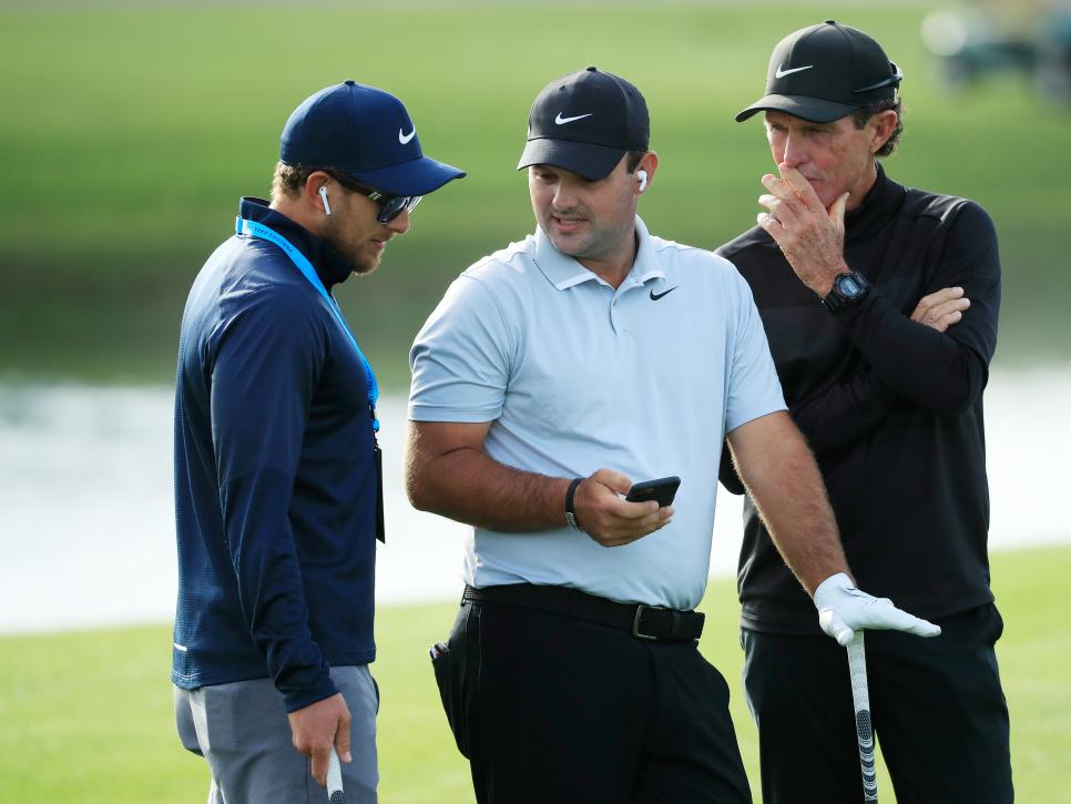 PONTE VEDRA BEACH, FLORIDA - MARCH 10: Patrick Reed of the United States talks to his swing coach Kevin Kirk and caddie Kessler Karain during a practice round prior to The PLAYERS Championship on The Stadium Course at TPC Sawgrass on March 10, 2020 in Ponte Vedra Beach, Florida. (Photo by Cliff Hawkins/Getty Images)