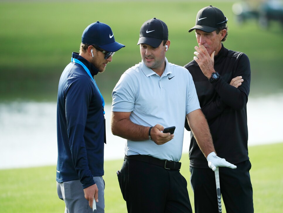 PONTE VEDRA BEACH, FLORIDA - MARCH 10: Patrick Reed of the United States talks to his swing coach Kevin Kirk and caddie Kessler Karain during a practice round prior to The PLAYERS Championship on The Stadium Course at TPC Sawgrass on March 10, 2020 in Ponte Vedra Beach, Florida. (Photo by Cliff Hawkins/Getty Images)