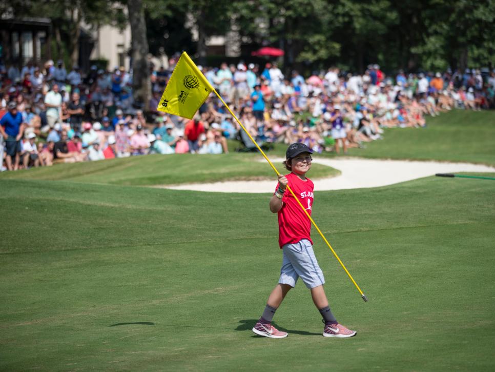 Honorary pin flag caddie, St. Jude patient Dakota smiles for the crowd on the 18th green during the championship round of the World Golf Championships - FedEx St. Jude Invitational at TPC Southwind on Sunday, July 28, 2019.