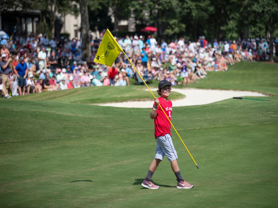 Honorary pin flag caddie, St. Jude patient Dakota smiles for the crowd on the 18th green during the championship round of the World Golf Championships - FedEx St. Jude Invitational at TPC Southwind on Sunday, July 28, 2019.