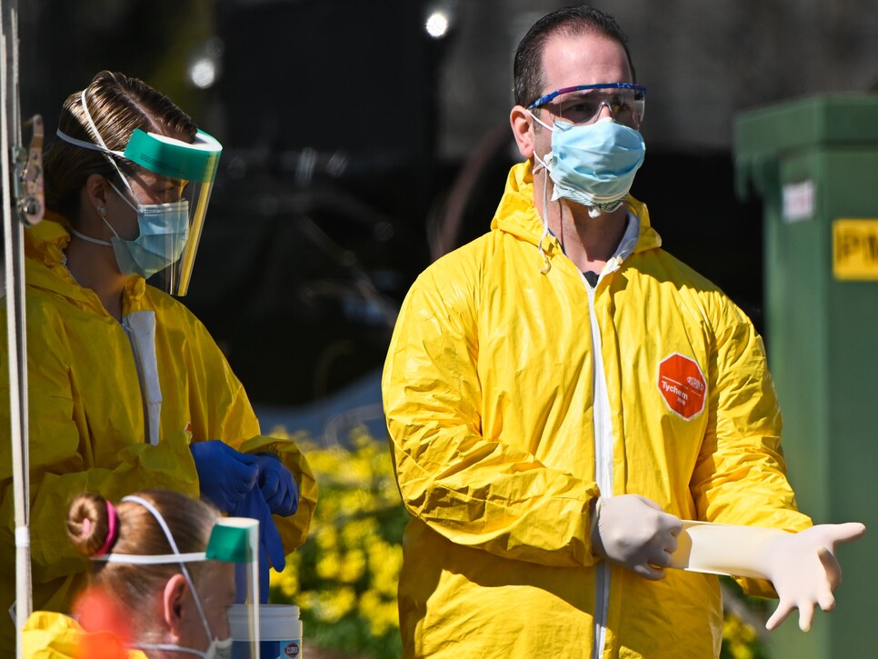 Healthcare worker puts on gloves at coronvirus testing facility