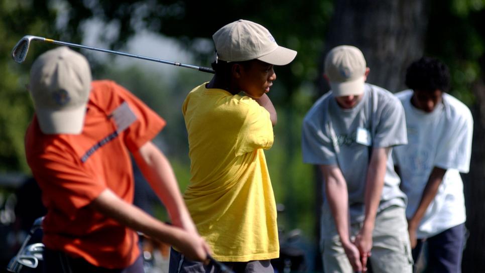 DENVER,CO, JUNE17, 2003--Anton<cq> Hopkins <cq> 13, (second from left) <cq> tees off at City Park's drving range Tuesday morning. <cq> Hopkins participates in The First Tee program, <cq>, at City Park golf course, a program designed to introduce golf to inner city youth. <cq> THE DENVER POST/ ANDY CROSS  (Photo By Andy Cross/The Denver Post via Getty Images)