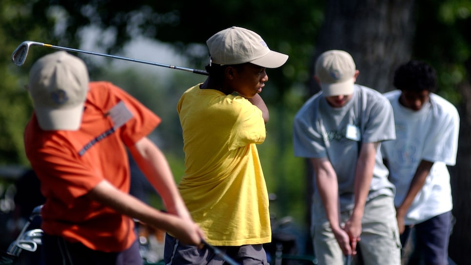 DENVER,CO, JUNE17, 2003--Anton<cq> Hopkins <cq> 13, (second from left) <cq> tees off at City Park's drving range Tuesday morning. <cq> Hopkins participates in The First Tee program, <cq>, at City Park golf course, a program designed to introduce golf to inner city youth. <cq> THE DENVER POST/ ANDY CROSS  (Photo By Andy Cross/The Denver Post via Getty Images)