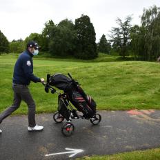 A golfer wears a facemask as he pushes his trolley ahead of a practice session at The "Bluegreen" Golf Course in Saint Aubin, south-west of Paris on May 11, 2020, on the first day of France's easing of lockdown measures in place for 55 days to curb the spread of the COVID-19 pandemic, caused by the novel coronavirus. (Photo by FRANCK FIFE / AFP) (Photo by FRANCK FIFE/AFP via Getty Images)