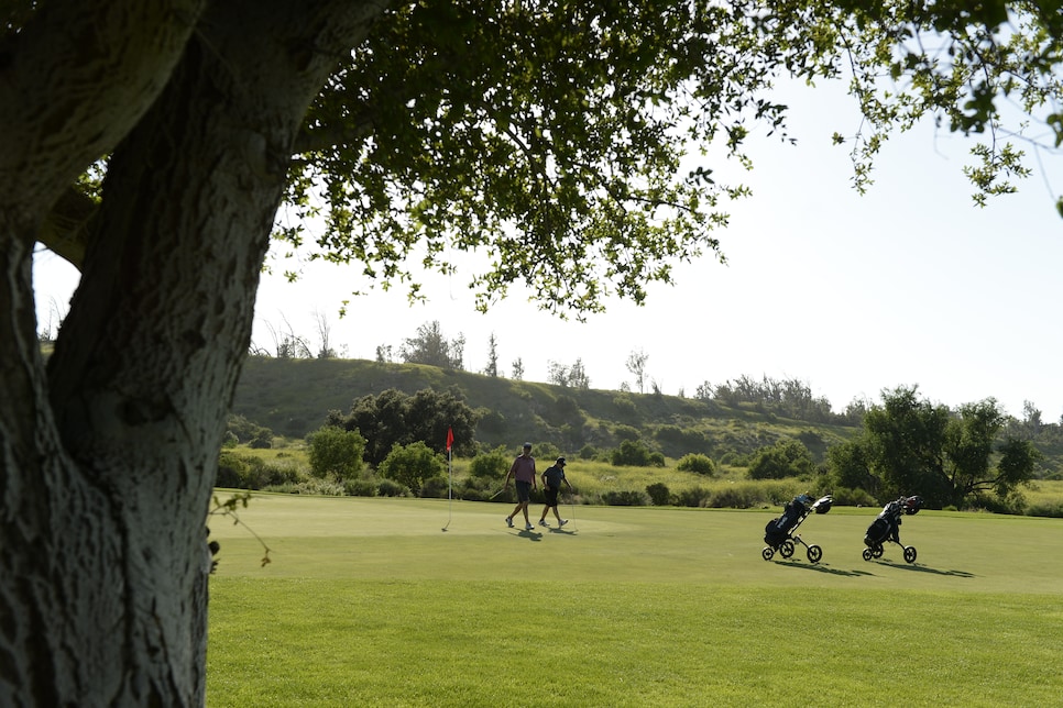 /content/dam/images/golfdigest/fullset/2021/10/golfers walking off green to bag.jpg