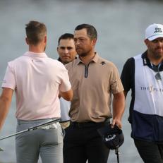 PONTE VEDRA BEACH, FLORIDA - MARCH 17: Wyndham Clark (L) and Xander Schauffele (2nd R) shake hands on the 18th green as caddie Austin Kaiser (2nd L) and caddie John Ellis (R) look on during the final round of THE PLAYERS Championship at Stadium Course at TPC Sawgrass on March 17, 2024 in Ponte Vedra Beach, Florida. (Photo by Logan Bowles/PGA TOUR via Getty Images)