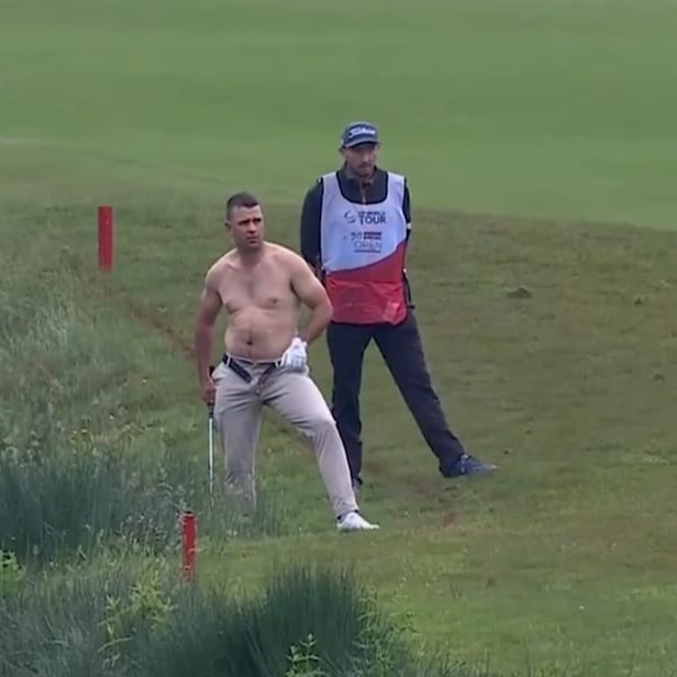 dp-world-tour-pro-takes-off-shirt-and-unbuckles-belt(?)-to-play-muddy-recovery-shot