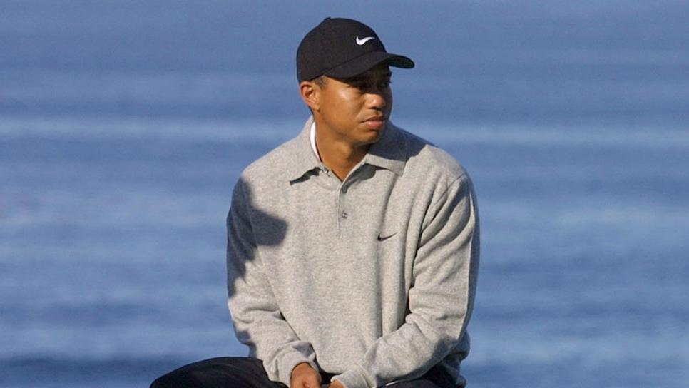 PEBBLE BEACH, UNITED STATES:  Tiger Woods, defending Champion of the AT&T Pebble Beach National Pro-Am Golf tournament, sits on a bench while waiting for his turn at the fourth Tee during the first round of the tournament 01 February 2001 in California. Woods injured his knee after stepping on a fan's foot at yesterday's practice rounds. He finished six-under-par.        AFP PHOTO John G. MABANGLO (Photo credit should read JOHN G. MABANGLO/AFP via Getty Images)