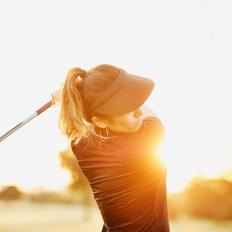 Woman hitting drive during early morning round of golf