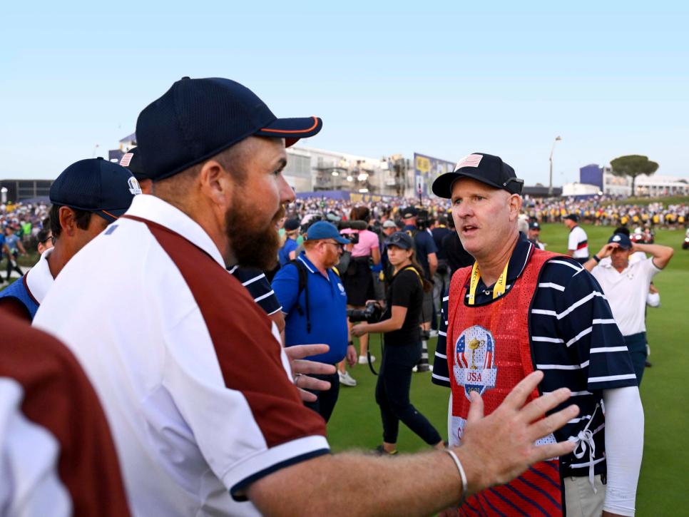 ROME, ITALY - SEPTEMBER 30: Shane Lowry of Team Europe interacts with caddie of Patrick Cantlay of Team United States (not pictured), Joe LaCava on the 18th green during the Saturday afternoon fourball matches of the 2023 Ryder Cup at Marco Simone Golf Club on September 30, 2023 in Rome, Italy. (Photo by Ross Kinnaird/Getty Images)