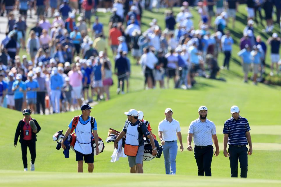 PONTE VEDRA BEACH, FLORIDA - MARCH 09: Rory McIlroy of Northern Ireland (L) Scottie Scheffler of The United States (R) and Jon Rahm of Spain walk off the tee on the 18th hole during the first round of THE PLAYERS Championship on THE PLAYERS Stadium Course at TPC Sawgrass on March 09, 2023 in Ponte Vedra Beach, Florida. (Photo by David Cannon/Getty Images)